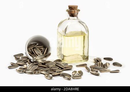 Sunflower oil in glass bottle and seeds isolated on white background. Cooking oil Stock Photo