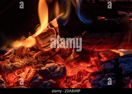 Close up shot of a small camp fire with glowing ember in a fire bowl, producing warmth and comfort in winter time Stock Photo