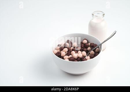 Round wheat flakes in a plate and milk in a bottle on a white background. Stock Photo