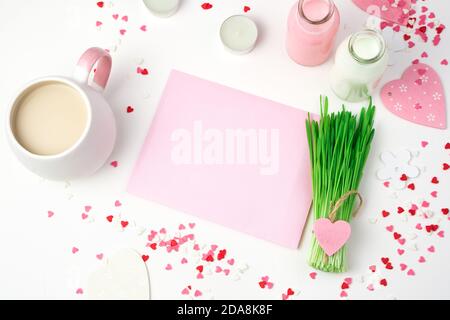 A Cup of coffee, a pink envelope and a decorative green bouquet on a romantic background. Stock Photo