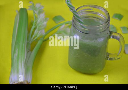 Green smoothie in glass mason jar over yellow background with copy space - detox, vegan, vegetarian healthy vegetable drink Stock Photo