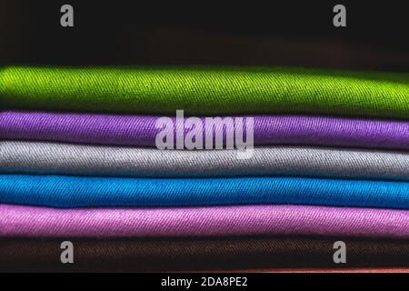 Green purple grey blue pink brown pile of textile, close up of colorful fabric, a pile of cashmere textile, stack of colorful clothes, pile of clothes Stock Photo