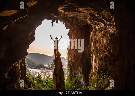 Man standing on top of limestone pinnacle, Vietnam Stock Photo
