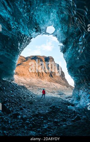 Solo female adventure traveler is discovering the ice caves in Iceland at Vatnajokull Glacier near to Jokulsarlon Glacier Lagoon. Tourism in abandoned Stock Photo