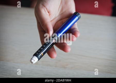 Hand holding injection pen for applying insuline Stock Photo