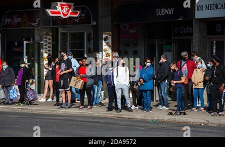 Toronto, Canada. 10th Nov, 2020. People wait for buses at a stop in Toronto, Canada, on Nov. 10, 2020. Canadian Prime Minister Justin Trudeau called on local governments Tuesday to do the right thing to stem record-breaking spikes of new COVID-19 cases across the country. As of Tuesday afternoon, Canada reported a total of 272,512 cases of the COVID-19 and 10,629 deaths, according to CTV. Credit: Zou Zheng/Xinhua/Alamy Live News Stock Photo