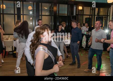 Portrait of young beautiful woman dancing with restaurant in the background, London, UK Stock Photo