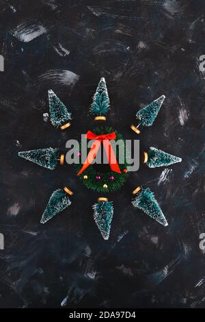 Christmas decorations and holiday spirit conceptual image, mini decorative Christmas pine trees with festive wreath in the center Stock Photo