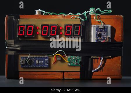 Bomb with red timer on black background. Improvised explosive device. Terrorist threat. Dynamite with clockwork. Explosives with detonator. Time bomb Stock Photo