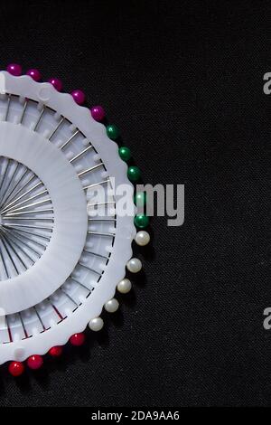 Set of colorful safety pins on black fabric background Stock Photo