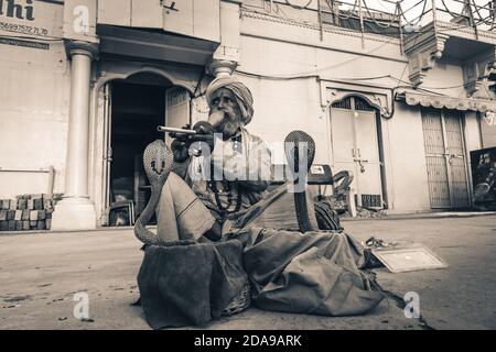 holy baba monk saint hypnotize a snake cobra kundalini with flute on the street of varanasi, India. Stock Photo