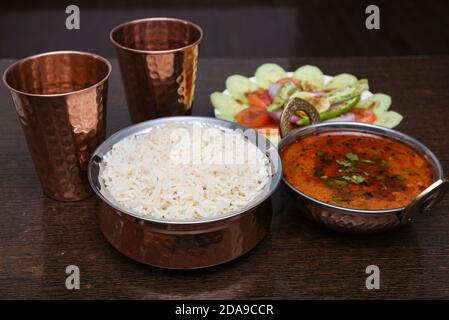 Traditional Rajasthan food thali Jaipur, India. White rice, missi , jowar roti side dish dal fry, gatta masala, baati ball, raita, churma sweet lassi Stock Photo