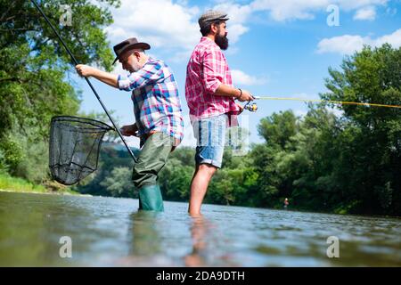 Portrait of two men on holiday. Retired dad and mature bearded son. Giving your hobby. Weekends made for fishing. Fishing skills. Leisure and people Stock Photo