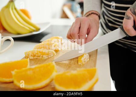Close-up image of woman cutting oranges when cooking dinner at home Stock Photo