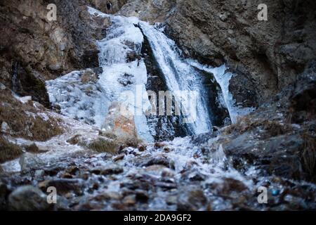 Hiking to the frozen waterfall at Issyk Ata in Kyrgyzstan's Chuy Oblast. Stock Photo