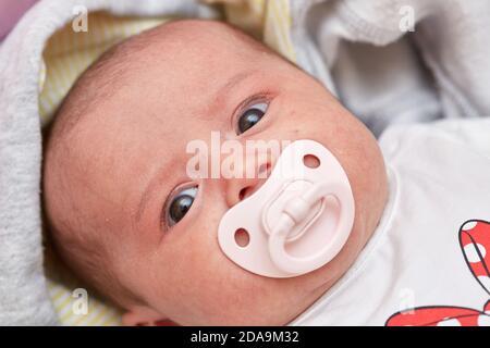 baby pacifier in the mouth of a month-old baby. close up. low depth of focus, selective focus. Stock Photo