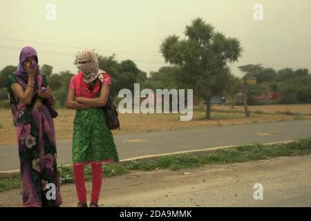 Women waiting to cross the road on NH 8 between Jaipur and New Delhi, India. Stock Photo