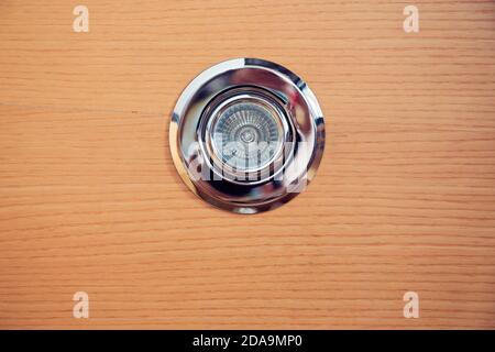 Halogen spot light bulb mounted on a wooden ceiling plank. Electricity expense concept. Stock Photo