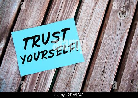Trust yourself. Motivational or inspirational quote handwritten on paper on a wooden table. Self confidence concept. Stock Photo