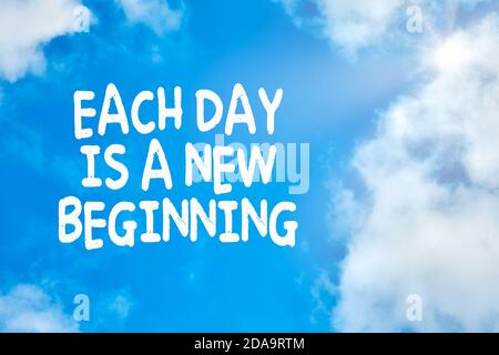 Each day is a new beginning motivational or inspirational quote against blue sky with clouds background. Stock Photo