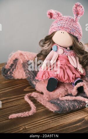 Closeup of a hand made fabric doll with natural hair and knitted clothes  Stock Photo