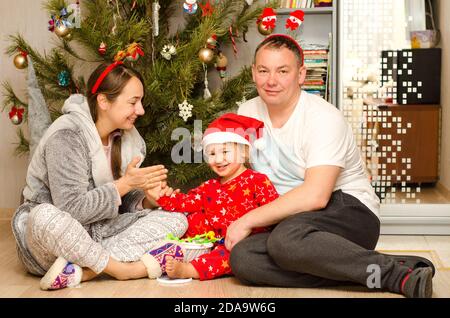 happy family sitting near christmas tree Stock Photo