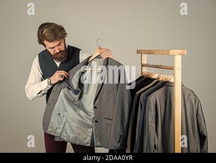 Man with suit. tailor in his workshop. Handsome bearded fashion man in classical costume suit. Man in custom tailored suit presenting expensive tailored tuxedo. Brand new stylish suit. Stock Photo