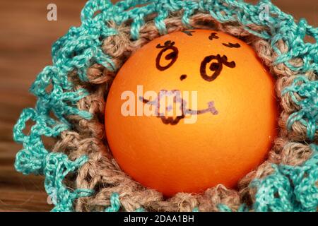 Closeup shot of a funny decorated Easter egg on a wooden surface Stock Photo