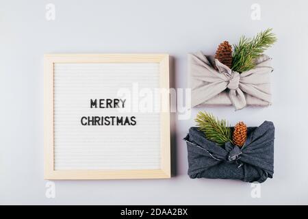 Christmas eco-friendly gift box furoshiki. Lightbox with text Merry Christmas. Zero waste concept. Stock Photo