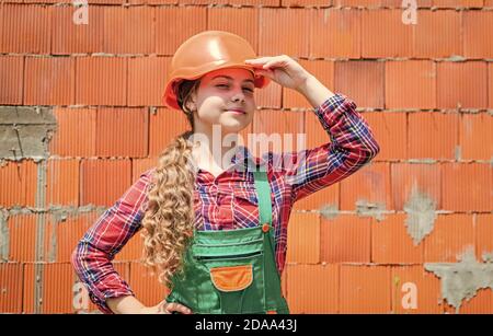 girl in helmet is construction worker. foreman teen child. kid work in the helmet. little girl in a helmet. girl making repairs. teen dressed in hard hat. concept of childhood development. Stock Photo