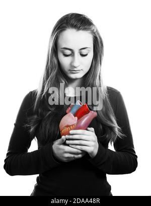 Young woman with heart in hand. Black and white image with local color on the heart Stock Photo