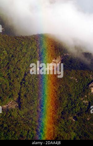 rainbow over a forest in the mountains, view from above Stock Photo