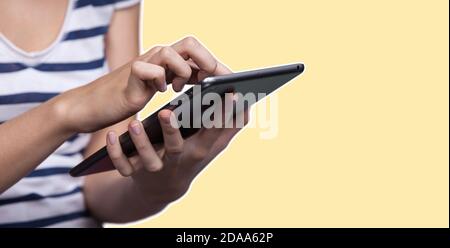 Education and lifestyle concept. Young woman using a digital tablet. Modern gadget in hand. Magazine style collage with copy space and yellow color ba Stock Photo