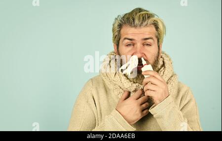Cold flu remedies. Runny nose recovery. Runny nose and symptoms of cold. Fast recovery. Man scarf hold nasal spray. Medicines effective recovery. Allergy medical treatment. Health problem. Sick leave. Stock Photo