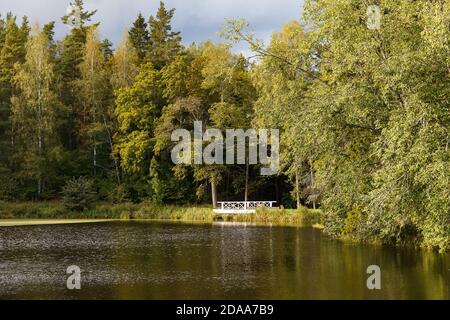 Big magnificent medieval manor in Estonia in Palmse. White wooden bridge in the park Stock Photo