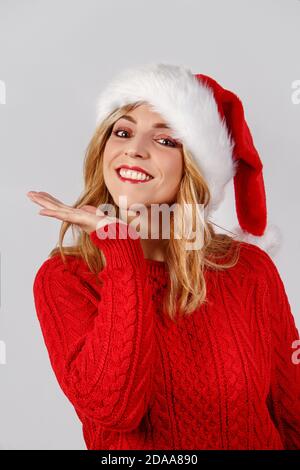 Young woman in santa hat smiling isolated on grey Stock Photo