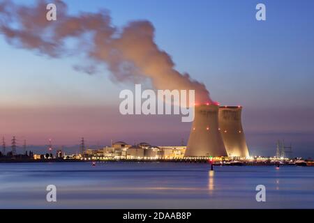 Riverbank with nuclear power plant Doel during a colorful sunset, Port of Antwerp, Belgium Stock Photo