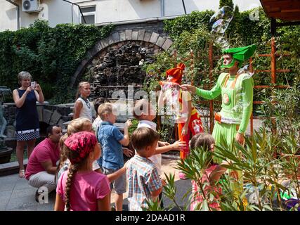 UZHGOROD, UKRAINE - Aug. 20, 2015: Clowns show soap bubbles to children during a children's holiday. Children and adults play soap bubbl Stock Photo