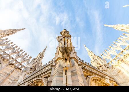 Roof of Milan Cathedral Duomo di Milano with Gothic spires and white marble statues. Top tourist attraction on piazza in Milan, Lombardia, Italy. Wide angle view of old Gothic architecture and art Stock Photo