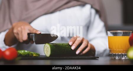 Muslim Woman's Hands Cutting Vegetables For Salad Cooking In Kitchen Stock Photo