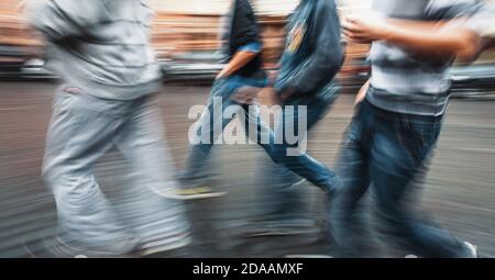 City life concept. People rushing in city. Abstract street scene in motion blur. A group of young guys walking down the street doing their business Stock Photo