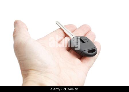 Closeup hand holds out a car key with remote control. Isolated on white background. Stock Photo
