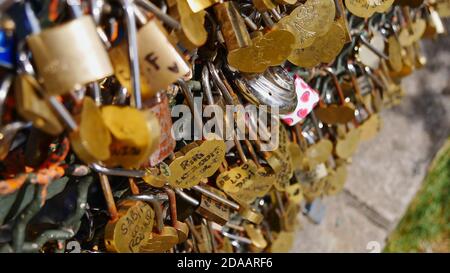 Closeup view of large number of golden colored love locks (padlocks) locked to a fence by sweethearts on Montmartre hill in Paris, France. Stock Photo