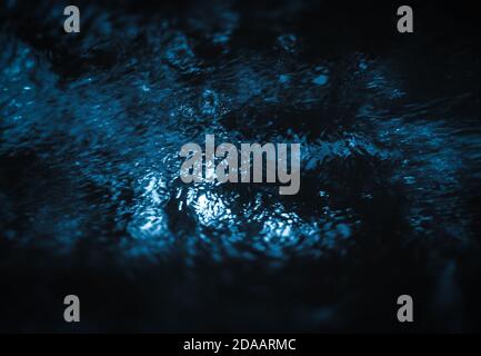 Abstract water grops background in dark blue dramatic tone. Water drops and splashing on glass Stock Photo