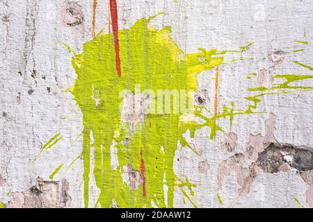 Stains of green, yellow and red paint on cracked plaster. Stock Photo