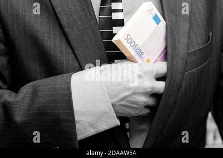 Man hides in a suit jacket pocket a bundle of banknotes 500 euros Stock Photo