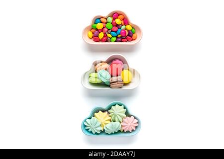 colorful candies - lollipops, meringues, macaroon in bowl in shape of cloud isolated on white background Flat lay Top View Knolling Unhealthy and Stock Photo