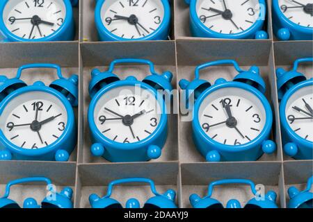 Colored clock alarm clocks in a cardboard box Stock Photo