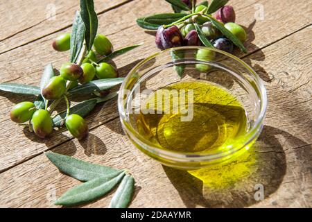 olive oil in glass transparent bowls on the wooden background in sunlights. Healthy mediterranean food. Stock Photo
