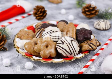 German gingerbread cookies with sugar and brown and white chocolate glazing in heart and star shape called 'Lebkuchen' on striped plate Stock Photo